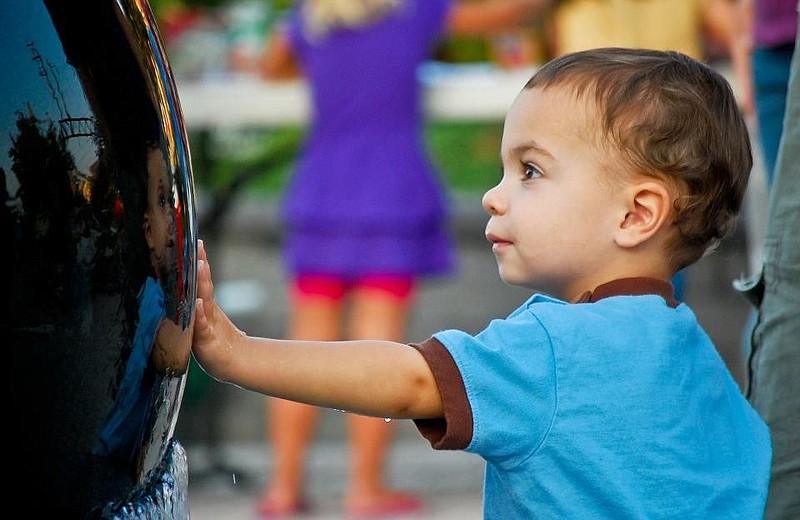 A child touching the kugel ball. 