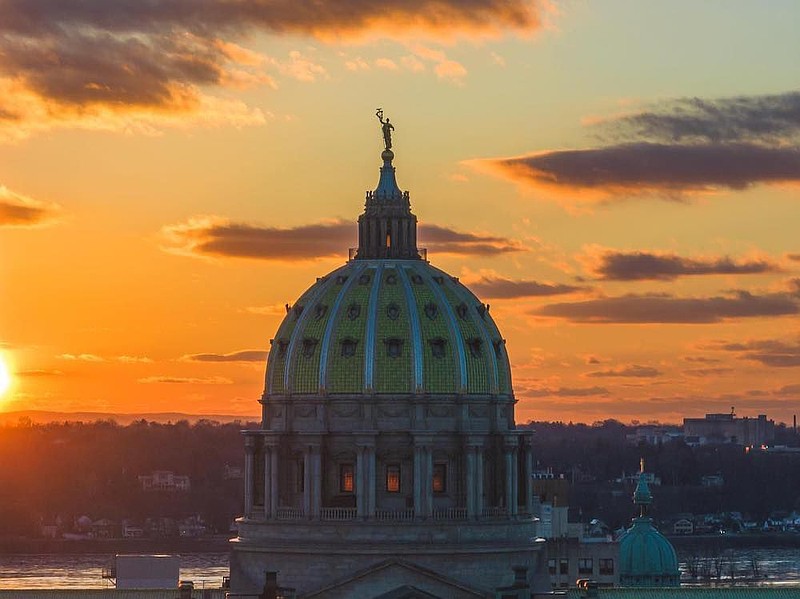 The sun rises over the state Capitol building in Harrisburg, Pennsylvania. (Credit: Michael Yatso Photography)