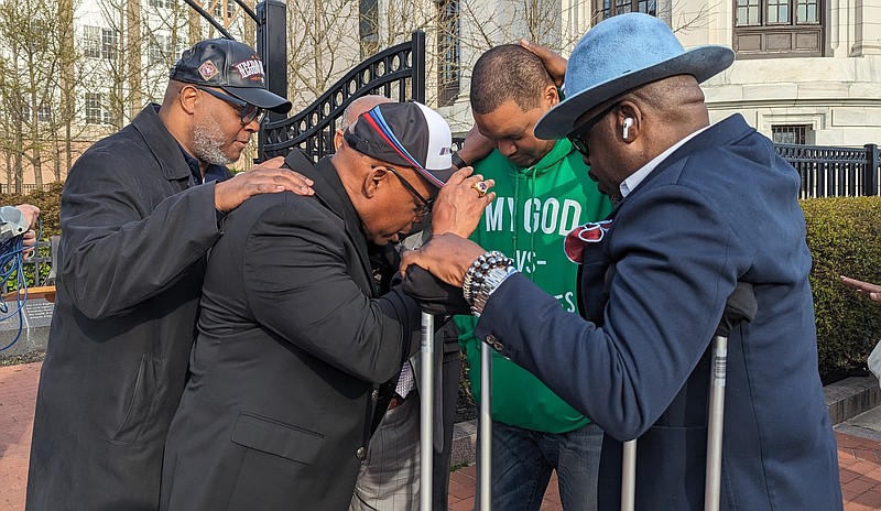 Mayor Marty Small, in green, prays with religious leaders after the rally.