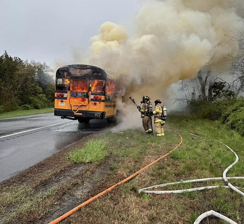 Smoke billows from the bus as firefighters extinguish the blaze.