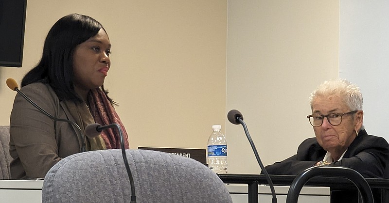 Superintendent La'Quetta Small talks with state monitor Carole Morris before a school board meeting.