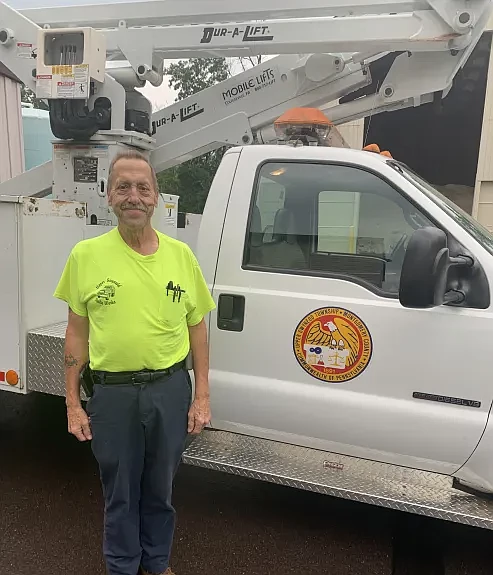 Longtime Upper Gwynedd Public Works Director Willard Troxel poses next to a public works utility truck.