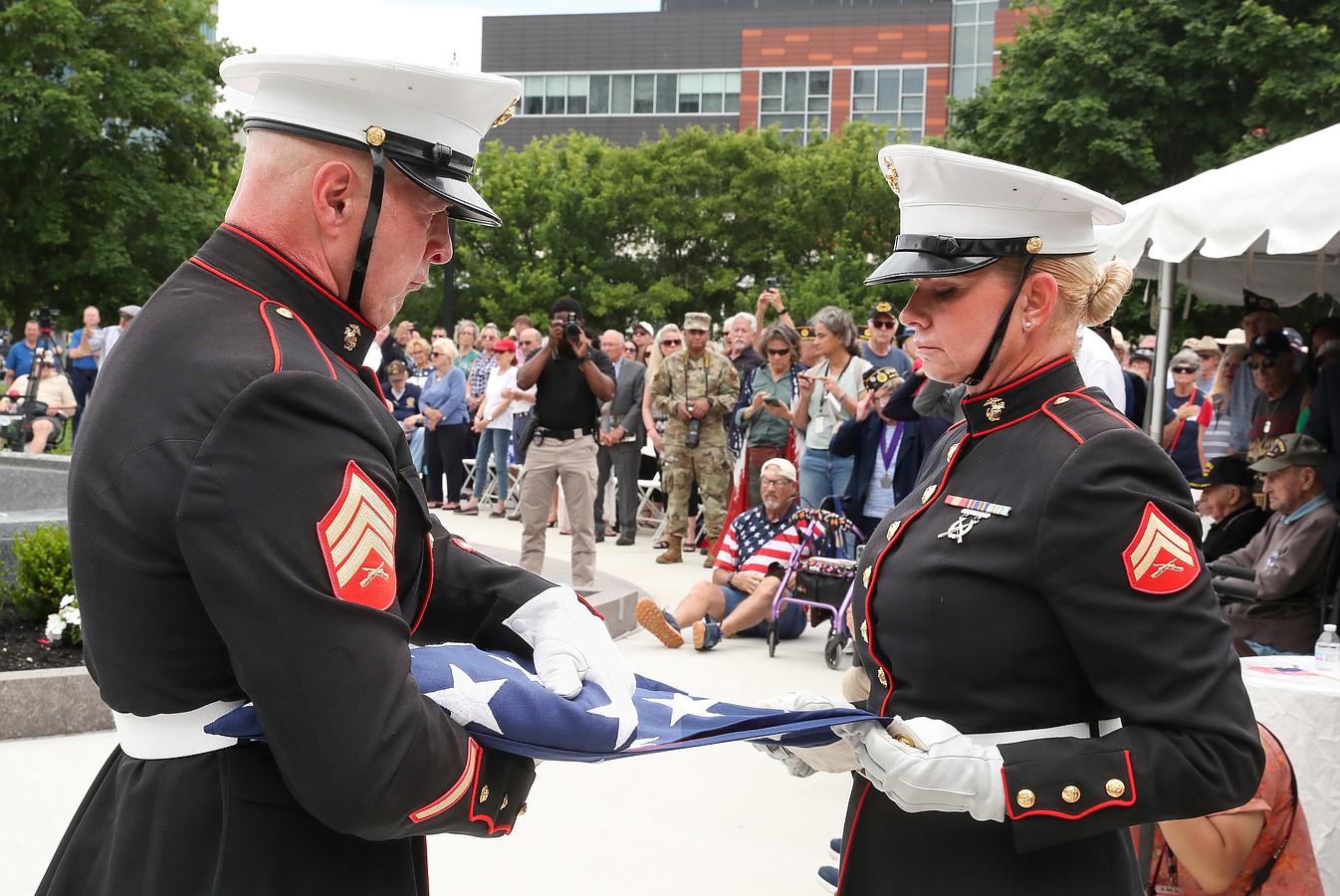 An American flag unfurled at the ceremony is folded for presentation.