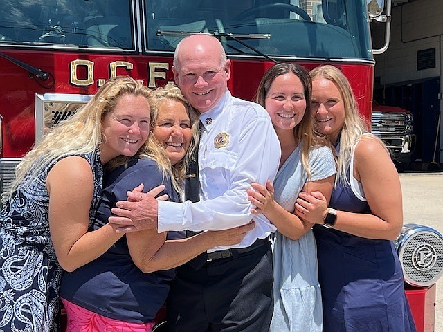 Newly retired Deputy Fire Chief Charlie Bowman and his wife, Jennifer, and their 
children, Kelsea, Katie and Caroline share a family hug during his retirement celebration. (Photos by Drew Fasy)