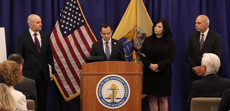 Attorney General Matthew Platkin announces the racketeering charges with defendant George Norcross seated in the front row, right.