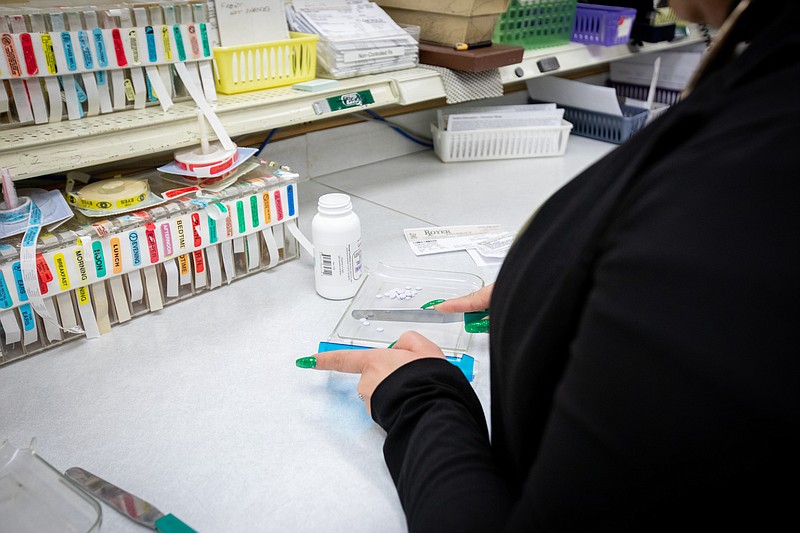 A pharmacy worker prepares a prescription. (Credit: Commonwealth Media Services)