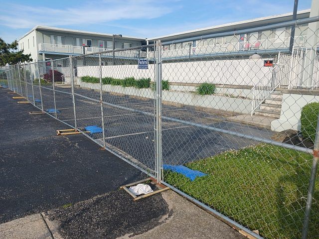 A chain-link fence blocks access to the Seaspray condos while they remain closed.