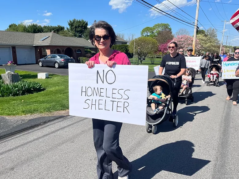 Susan Salkowski, of Eagleville, holds a sign as she participates in a march on April 20, 2024 protesting a proposed short term housing facility in Lower Providence Township.