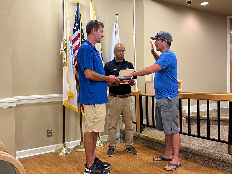 Longport Mayor Nicholas Russo swears-in Daniel Gordon as a lieutenant on the Longport Beach Patrol, while Chief Tom Kresz holds the Bible.