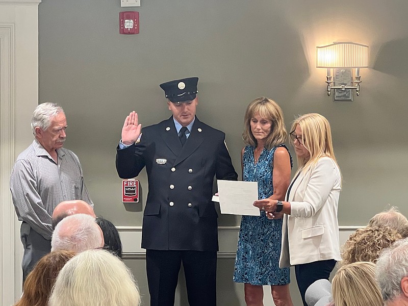 Margate Commissioner Cathy Horn administers the oath of office for Firefighter Steven Hickey, while family members stand in support.