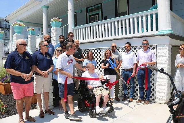 A ceremonial ribbon-cutting marks the grand opening of The Cove Beach Hotel.