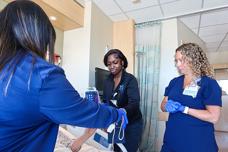 Stockton student Amiesa Paasewe, left, helps a patient along with Clinical Manager Lori Oberman at AtlantiCare Regional Medical Center's City Campus. (photo by Lizzie Nealis/Stockton University)