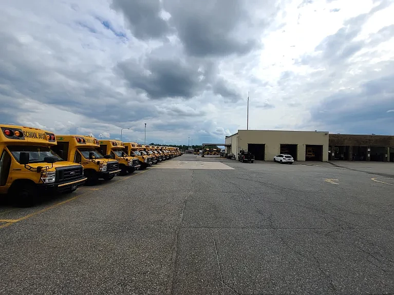 School buses stand parked next to the North Penn School District’s transportation center on the campus of North Penn High School in June 2024.