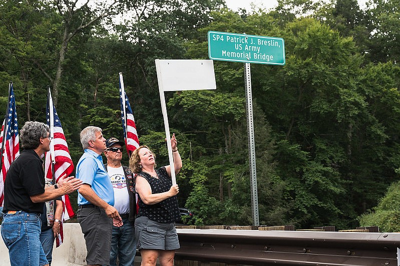 Jessica Bonner, sister of SP4 Patrick J. Breslin, unveils the new bridge name in Breslin's honor