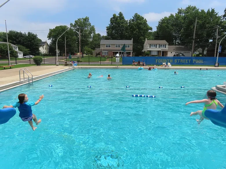 Sisters Katie, left, and Grace Quinn of Lansdale emerge from water slides into a splashdown into the Fourth Street pool on Tuesday, July 13 2021