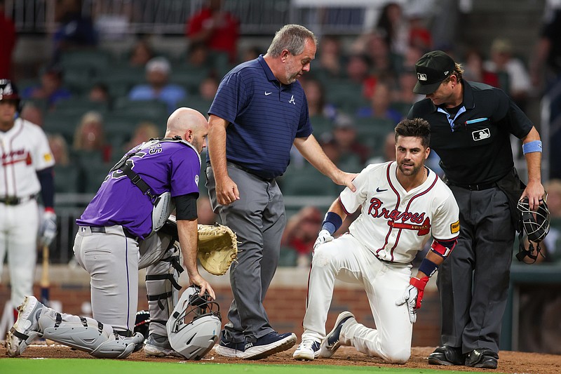 Sep 3, 2024; Atlanta, Georgia, USA; Atlanta Braves second baseman Whit Merrifield (15) is talked to by assistant athletic trainer Jeff Stevenson after being hit in the head with a pitch as Colorado Rockies catcher Jacob Stallings (25) looks on in the seventh inning at Truist Park. Mandatory Credit: Brett Davis-Imagn Images .