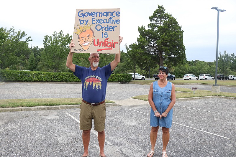 Michael Butler and his wife, Jeanne, display a sign critical of Gov. Phil Murphy for his executive order introducing the climate-control regulations.