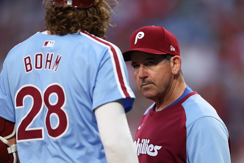 Aug 29, 2024; Philadelphia, Pennsylvania, USA; Philadelphia Phillies manager Rob Thomson (R) checks third base Alec Bohm (28) after an apparent injury during the first inning against the Atlanta Braves at Citizens Bank Park. Mandatory Credit: Bill Streicher-USA TODAY Sports