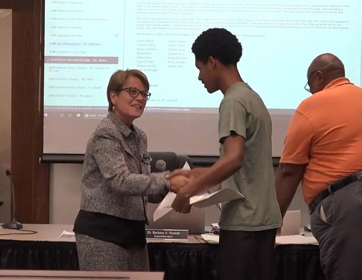 Perkiomen Valley School District Superintendent Dr. Barbara Russell congratulates high school student Legend Fields on his Peru trip, along with 14 other peers.