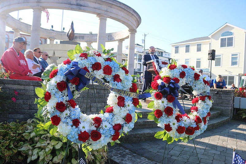 Memorial wreaths frame the monument at Veterans Park during the 2024 Patriot Day ceremony