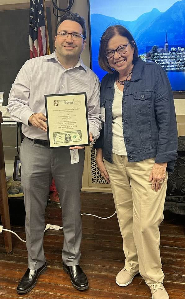 Eric Traub, left, accepts the annual $1 rent from Wissahickon Valley Historical Society's President Carol Kalos. (Credit: WVHS)