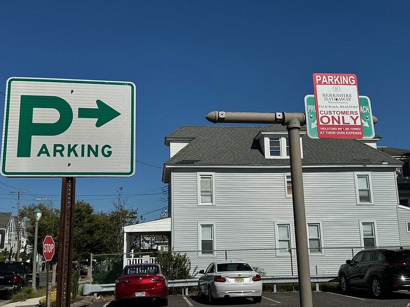 Signage indicates parking is for customers of Berkshire Hathaway real estate office.