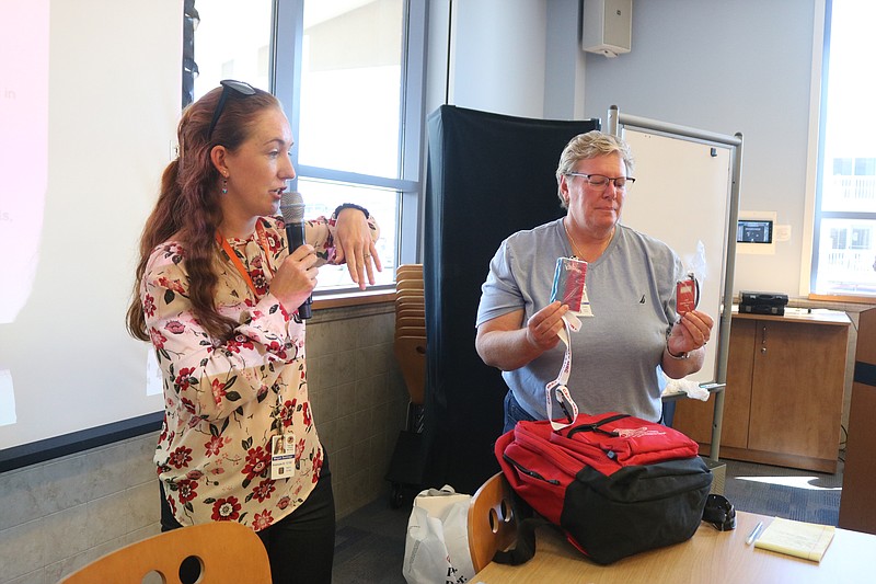 Megan Santiago, left, and Mary Tighe of the Cape May County Health Department, show some of the essential items that are included in storm "Go Bags."