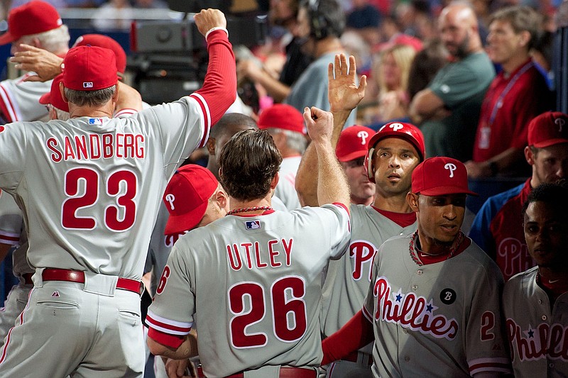 September 28, 2011; Atlanta, GA, USA; Philadelphia Phillies left fielder Raul Ibanez (29) (batting helmet) shakes hands with team mates in the dugout after scoring a run against the Atlanta Braves during the seventh inning at Turner Field. Mandatory Credit: Dale Zanine-USA TODAY Sports