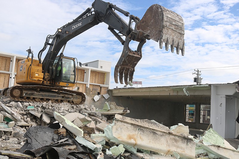 An excavator's gaping claw tears down the old LaCosta Lounge.