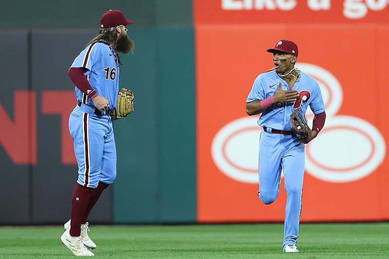 Oct 12, 2023; Philadelphia, Pennsylvania, USA; Philadelphia Phillies center fielder Johan Rojas (18) celebrates with left fielder Brandon Marsh (16) after catching the fly ball of Atlanta Braves designated hitter Marcell Ozuna (20) to end the top of the seventh inning during game four of the NLDS for the 2023 MLB playoffs at Citizens Bank Park. Mandatory Credit: Bill Streicher-USA TODAY Sports