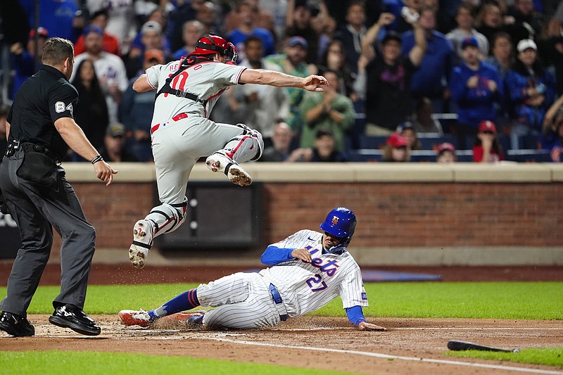 Sep 22, 2024; New York City, New York, USA;  New York Mets third baseman Mark Vientos (27) slides safely into home plate ahead of the throw to Philadelphia Phillies catcher J.T. Realmuto (10) on New York Mets center fielder Tyrone Taylor (not pictured) RBI single during the second inning at Citi Field. Mandatory Credit: Gregory Fisher-Imagn Images