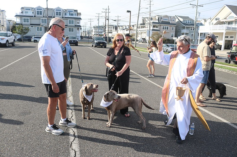 Father Perry Cherubini blesses the animals with a gentle sprinkling of holy water.