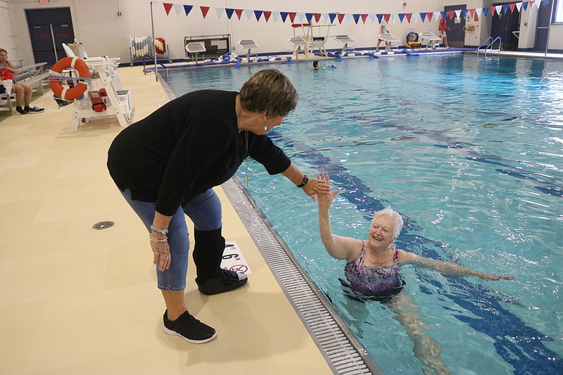 Friends and fellow swimmers Leslie Jordan, left, and Rosemarie Madden celebrate the pool's reopening with a high-five.