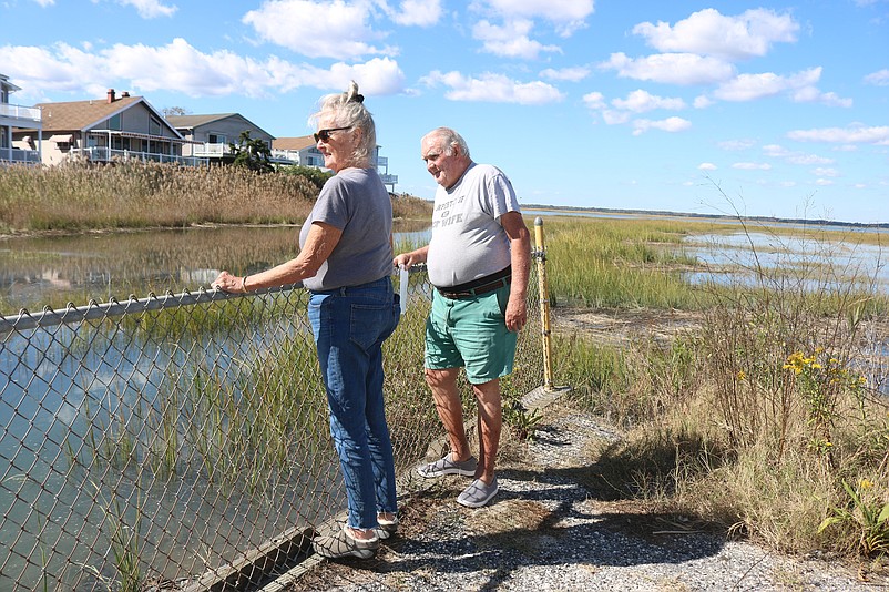 Margaret and Kevin Kavanagh peer over the fence to look at the old bulkhead that is supposed to protect their 75th Street neighborhood from flooding.