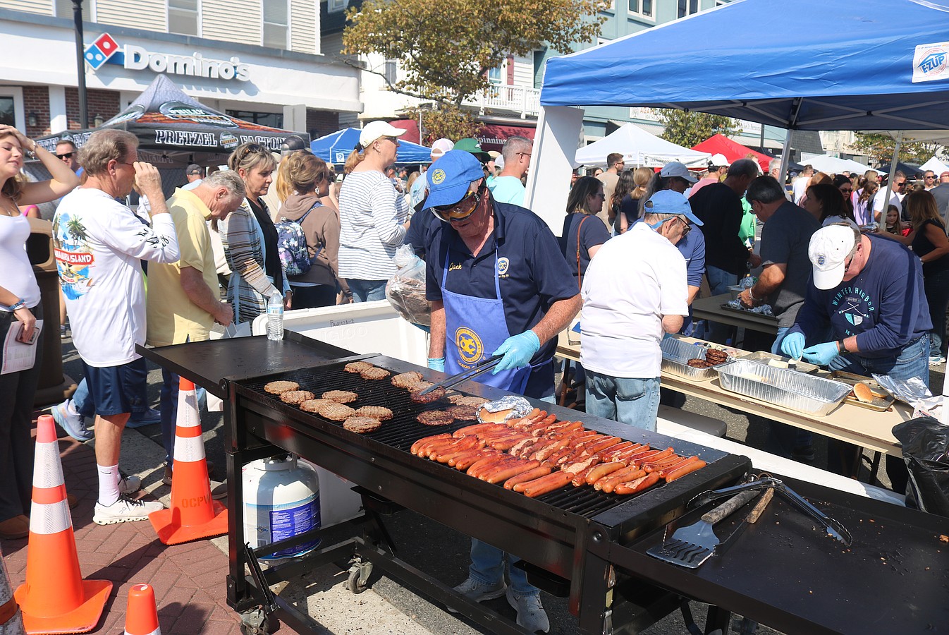 Jack Hagan, of the Ocean City Exchange Club, cooks some hotdogs and hamburgers on the grill for the lunchtime crowds.