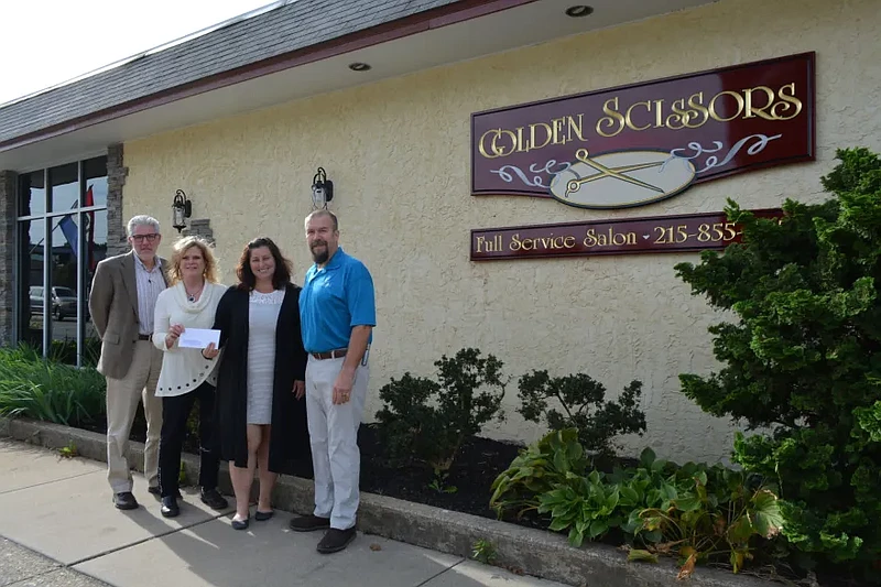 Lansdale Borough officials present a check to Rita Brown, owner of Golden Scissors Salon in Lansdale, as the first recipient of a borough Facade Improvement Grant in 2018. From left to right are Borough Manager John Ernst, Brown, then-Economic Development Committee Chairwoman Carrie Hawkins Charlton and former EDC Chairman Jason Van Dame. (Credit: Lansdale Borough)