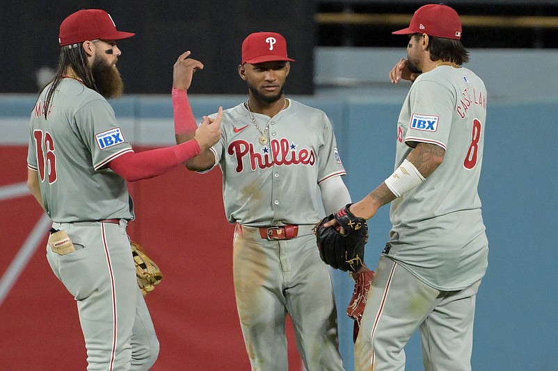 Aug 7, 2024; Los Angeles, California, USA;  Philadelphia Phillies left fielder Brandon Marsh (16), Philadelphia Phillies center fielder Johan Rojas (18) and Philadelphia Phillies right fielder Nick Castellanos (9) celebrate after the final out of the ninth inning against the Los Angeles Dodgers at Dodger Stadium. Mandatory Credit: Jayne Kamin-Oncea-USA TODAY Sports