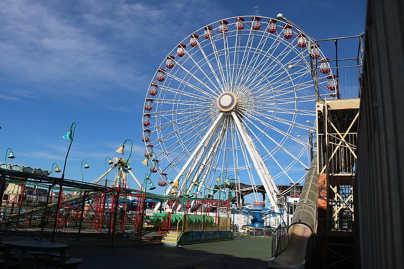 A fence blocks access to the now-closed Wonderland rides, including the towering Ferris wheel.