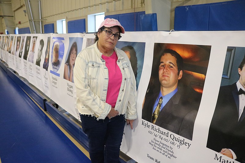 Cathy Quigley somberly stands next to a photo of her late son, Kyle Quigley, who was killed by a drunken driver in 2015.