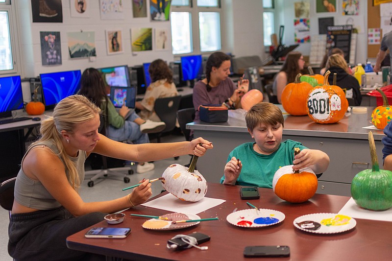 Two students decorate pumpkins for the opening of Pumpkins in the Park 
on Oct. 25. (Courtesy of Ocean City School District)