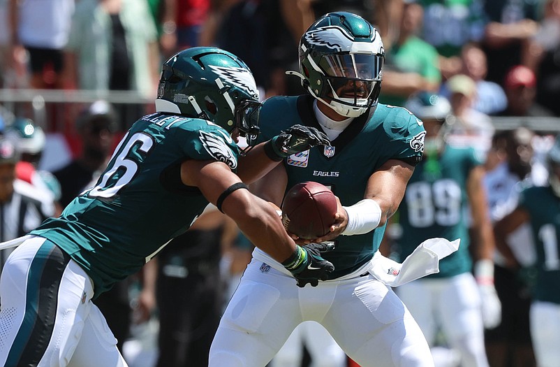 Sep 29, 2024; Tampa, Florida, USA;Philadelphia Eagles quarterback Jalen Hurts (1) hands the ball off to Philadelphia Eagles running back Saquon Barkley (26) against the Tampa Bay Buccaneers  during the first quarter at Raymond James Stadium. Mandatory Credit: Kim Klement Neitzel-Imagn Images