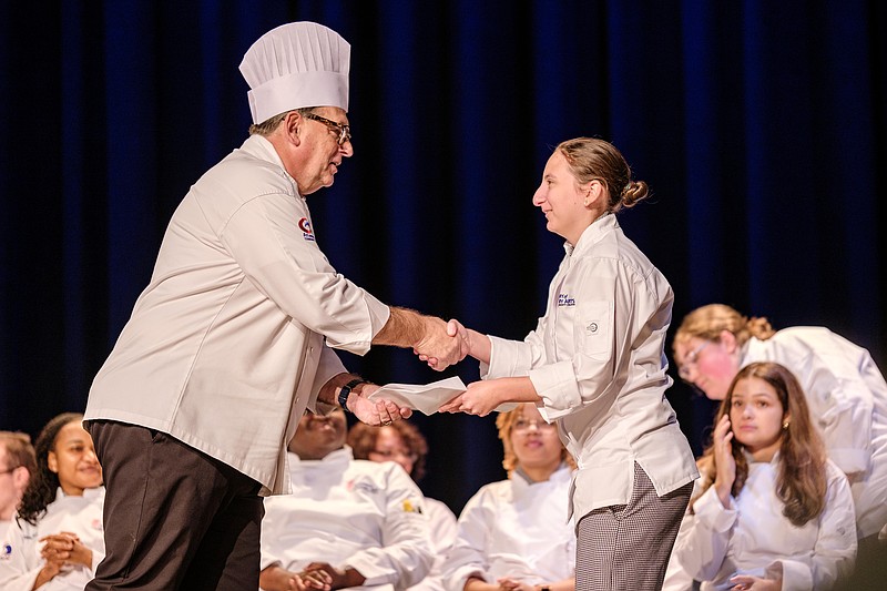 Atlantic Cape/ACA Director Joseph Sheridan presents culinary student Haley Richards with her toque.