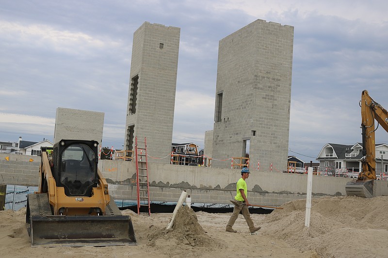 The community center begins to take shape, including the towering concrete elevator shafts and stairwells in the background.