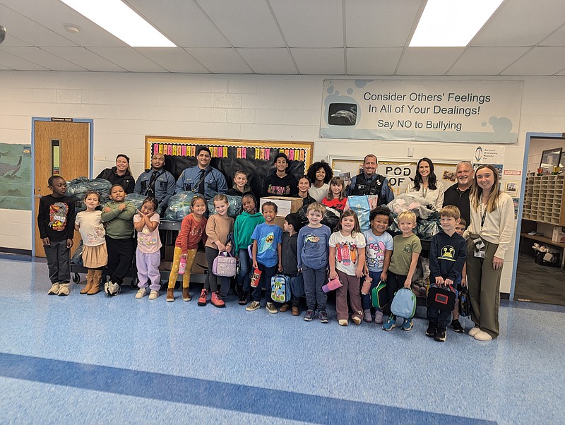 Kindergarteners, teachers and State Police pose with the more than 8,000 collected by Smithville Elementary School students.