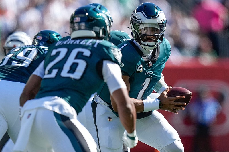 Philadelphia Eagles quarterback Jalen Hurts (1) drops back to hand off to running back Saquon Barkley (26) in the first quarter of the NFL Week 8 game between the Cincinnati Bengals and the Philadelphia Eagles at Paycor Stadium in downtown Cincinnati on Sunday, Oct. 27, 2024.