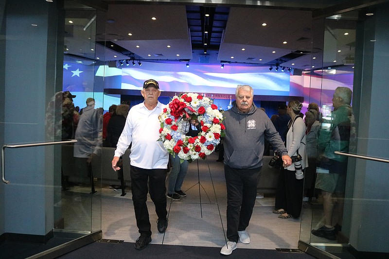 John Kocher, left, of American Legion Post 524, and Frank Timmons, of VFW Post 6650, carry the memorial wreath.