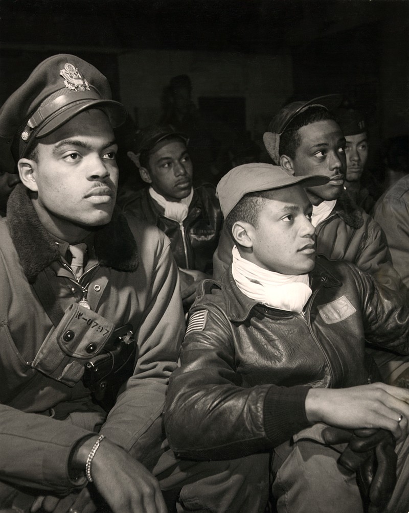 (Credit: Photograph by Toni Frissell) Members of the 332nd Fighter Group (Tuskegee Airmen) attending a briefing in Ramitelli, Italy. Members of the 332nd, from left to right: Robert W. Williams, Ottumwa, IA, Class 44-E; (leather cap) William H. Holloman, III, St. Louis, Mo., Class 44-?; (cloth cap) Ronald W. Reeves, Washington, D.C., Class 44-G; (leather cap) Christopher W. Newman, St. Louis, MO, Class 43-I; (flight cap) Walter M. Downs, New Orleans, LA, Class 43-B (Source: Photographer's notes and Tuskegee Airmen 332nd Fighter Group pilots.), March, 1945.