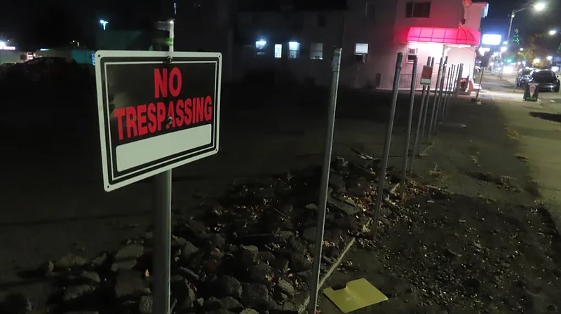 A row of posts, some with ‘No Trespassing’ signs, stands at 817 West Main Street on the site of a proposed apartment building project, as seen on Wednesday, Nov. 6, 2024.