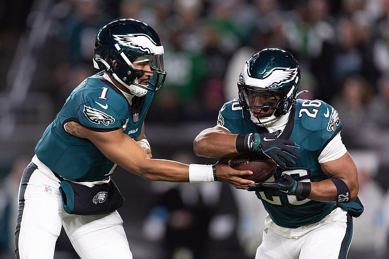 Nov 14, 2024; Philadelphia, Pennsylvania, USA; Philadelphia Eagles quarterback Jalen Hurts (1) hands off to running back Saquon Barkley (26) during the first quarter against the Washington Commanders at Lincoln Financial Field. Mandatory Credit: Bill Streicher-Imagn Images