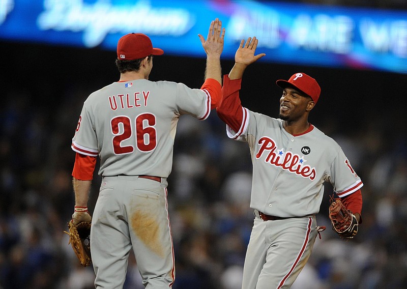 October 15, 2009; Los Angeles, CA, USA; Philadelphia Phillies shortstop Jimmy Rollins (11) and second baseman Chase Utley (26) celebrate following their 8-6 victory over the Los Angeles Dodgers in game one of the 2009 NLCS at Dodger Stadium. Mandatory Credit: Christopher Hanewinckel-USA TODAY Sports